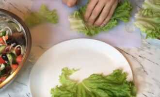 На тарелку выкладываем листья салата.