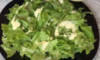 Перемешать листья салата с заправкой